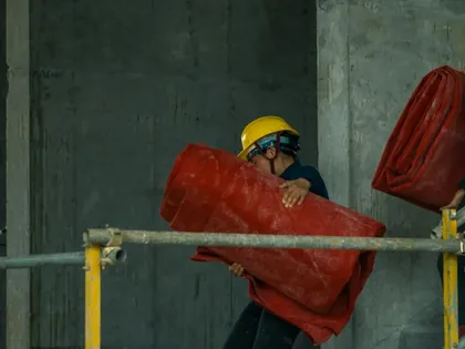 Ouvrier portant une charge sur un chantier