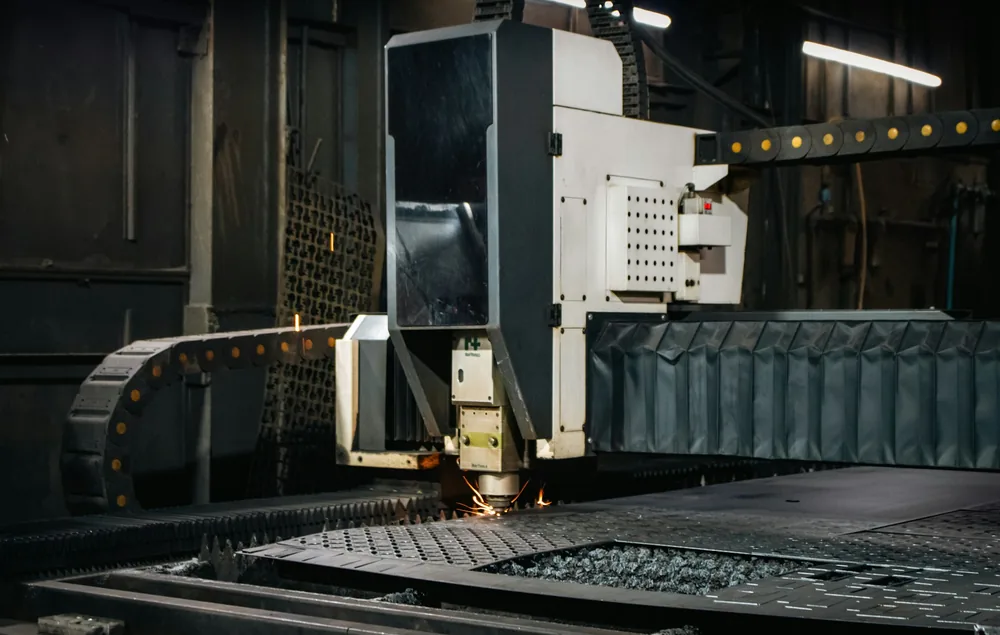 Machine de découpe laser sur une tôle, avec des étincelles