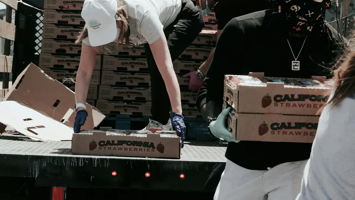 Salariés déchargeant des cartons à l'arrière d'un camion